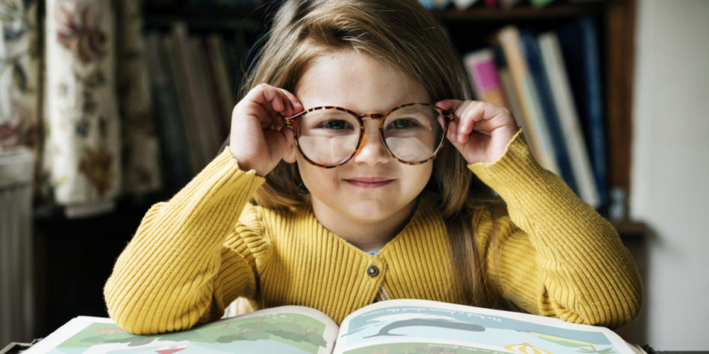 Kleines lächelndes Mädchen mit großer Brille