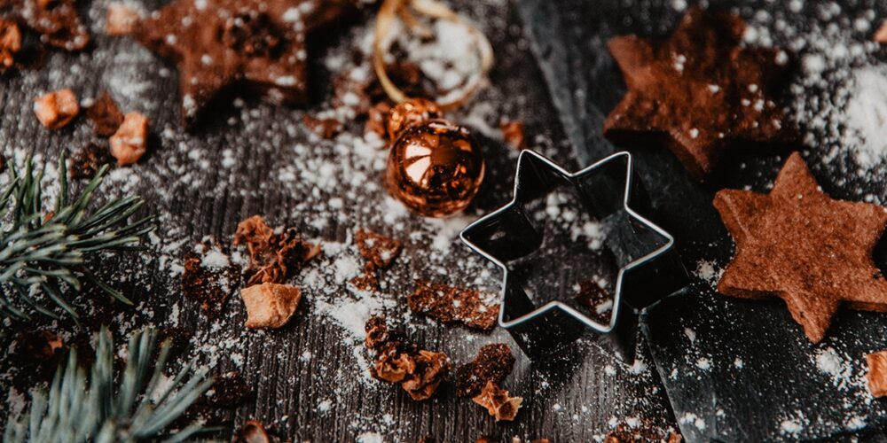 Adventstisch Tisch mit Keksförmchen, Keksen, Puderzucker und Tannenzweigen