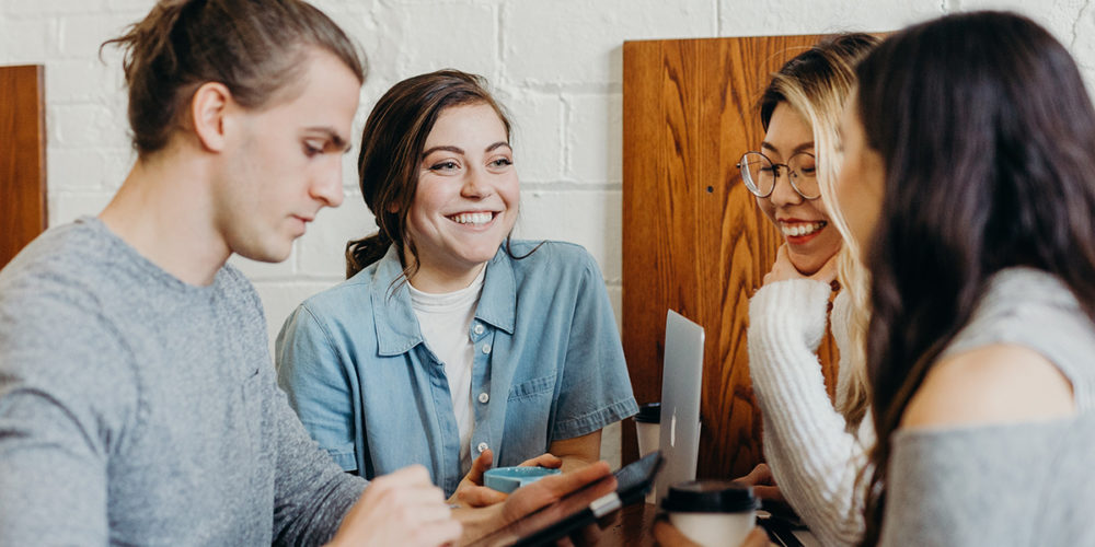 Gruppe junger Leute, die sich lächelnd unterhalten